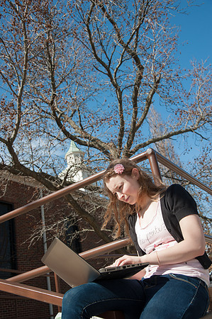 Amanda Stoner on laptop outside of Miller Chapel.